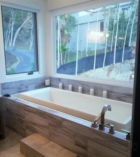 Hill House master bathroom with bidet, freestanding soaking tub, glass shower, and double sink vanity.