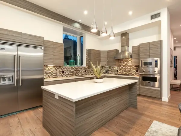 Modern chef’s kitchen with island, pendant lighting, and mosaic backsplash.